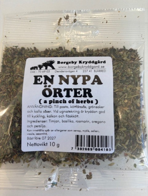Ett genomskinligt paket märkt "En nypa örter 10g" som innehåller en blandning av torkade örter.
