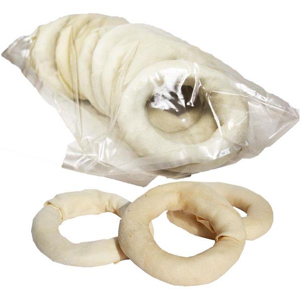 Klar plastpåse med flera vita tuggringar av råhud och tre ringar utanför påsen.