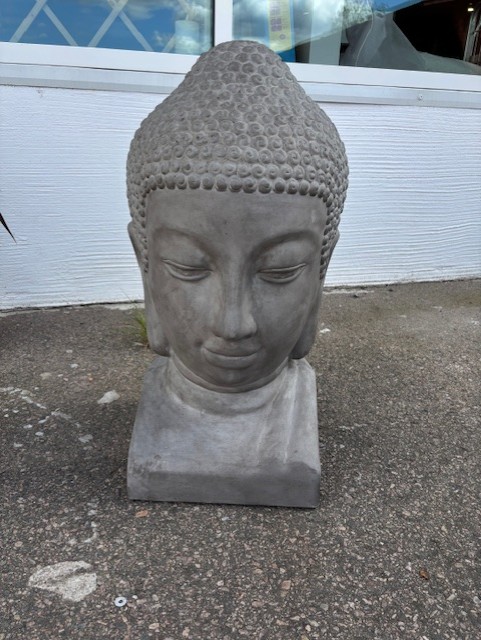 Statyn Buddha Zen H 90 är placerad på betong mot en vit vägg.
