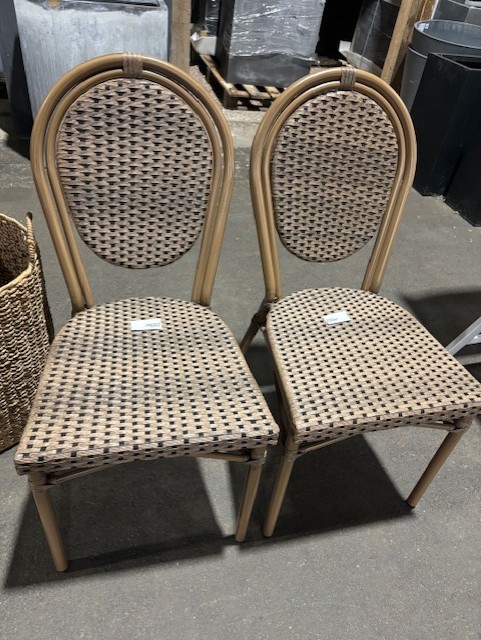Två Stol 651 stolar i flätad rotting med rundade ryggar på ett betonggolv.