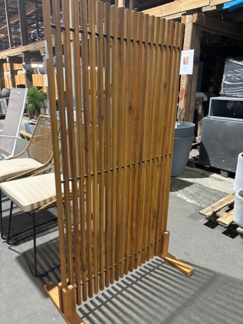 Avskiljare i trä står på betonggolv i en utställning i en utomhusbutik.