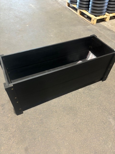 Den svarta planteringslådan Odlingslåda 105x39x40 står på ett betonggolv inomhus.