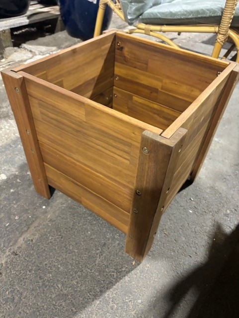 En Odlingslåda 39x39x40 planteringslåda står på ett betonggolv.