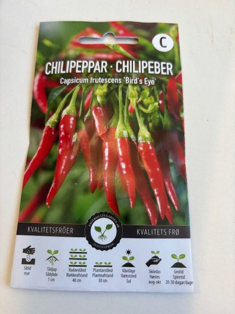 Förpackning med Chilipeppar 'Bird's eye'-frön med röda chilifrukter på framsidan.