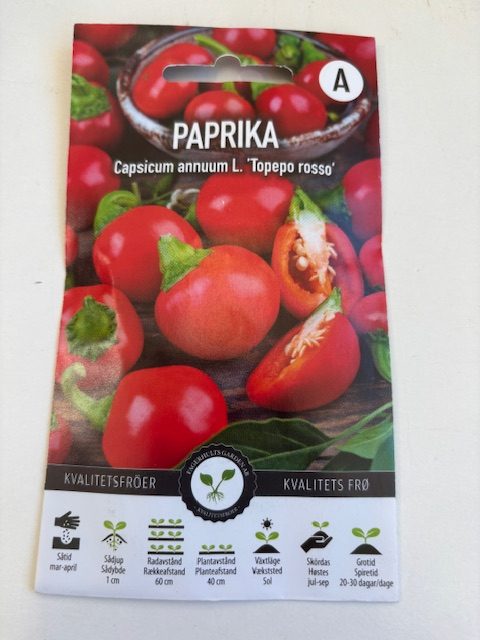 Förpackning med Paprika 'Topepo rosso' frön med bilder av runda röda paprikor på framsidan.