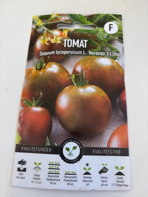 Förpackning med Tomat ´Nerondo´F1-frön med foton av mogna brunröda tomater på framsidan.
