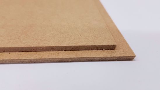 Två skivor av Hardboard standard/masonit staplade på en vit yta.