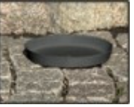 A Fat plast svart 47cm till kruka 86400 vilar på ojämna stenblock.