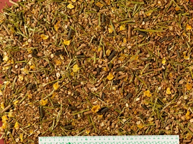 Närbild av blandat djurfoder med en linjal längst ner för skala.
