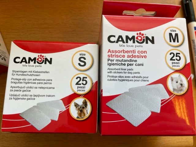 Två lådor Bindor till tikskydd - Små, 25 stycken vardera, placerade på ett bord.