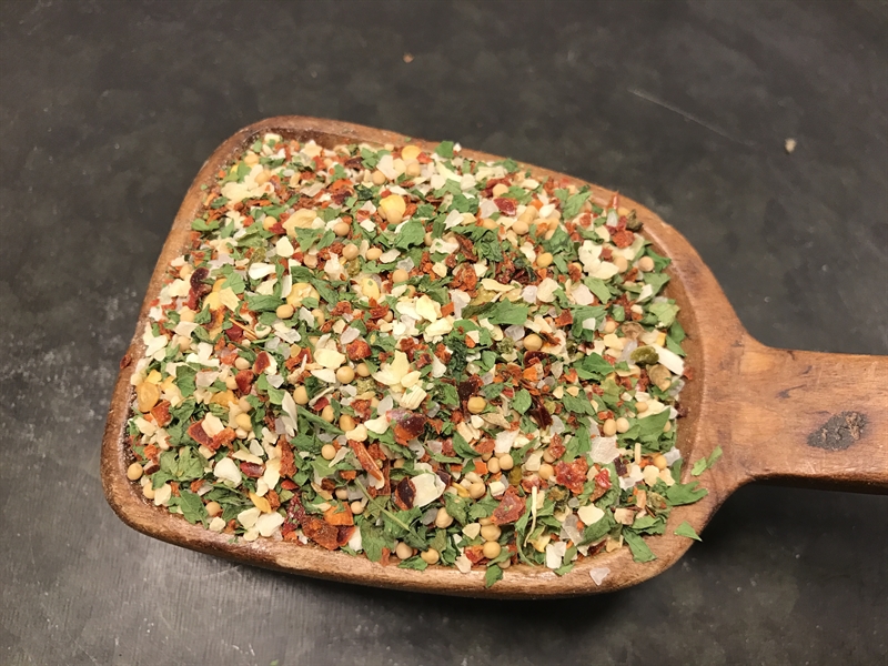 En träsked fylld med en färgstark blandning av örter och kryddor från chimmi-churri.