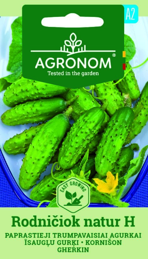 En bricka med färsk gurka, Rodniciok Natur med ett fröpaket märkt AGRONOM ovanför.