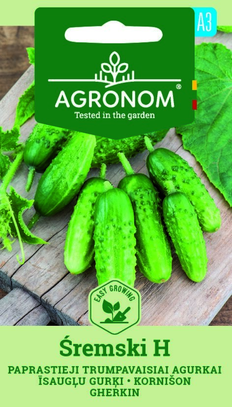 Flera färska Sremski H-gurkor på en bräda, med Agronom-fröpaketets varumärke ovanför.