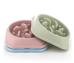 Två pastellfärgade Slow-skålar för ätande husdjur staplade på varandra mot en vit bakgrund.