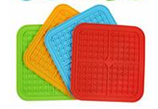 Fyra Slickmatta silikonmattor staplade i grönt, orange, blått och rött.