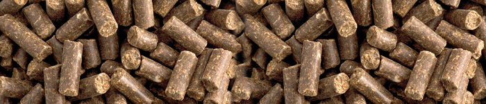 Närbild av bruna djurfoderpellets som ligger i ett tätt, överlappande mönster.