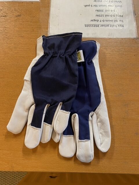 Bluewear Vit arbetshandske handskar i blått och vitt på en träyta av ett tryckt papper.