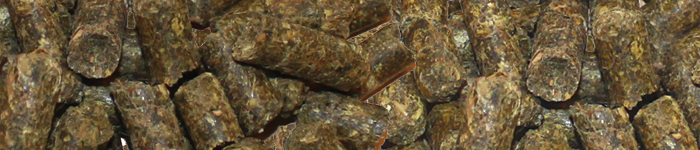 Närbild av bruna, cylindriska djurfoderpellets som packats ihop.