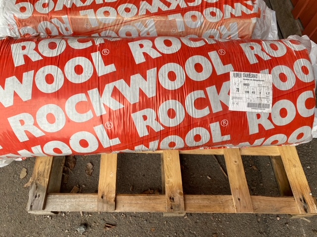 Rockwool isoleingsbal stor rulle på pall i röd och vit förpackning.