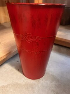 Röd metallkruka - x-small med präglat hjärtmotiv på betonggolv.