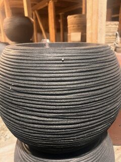 KRUKA CAPI RIB SVART D40 är en rund, ribbad svart planteringsmaskin som används i verkstäder.