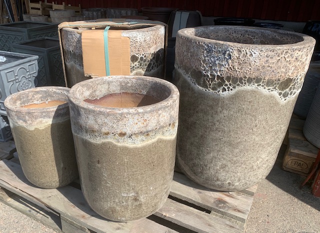 Fyra XL beige "Keramik kruka" krukor visas utomhus på en träpall.