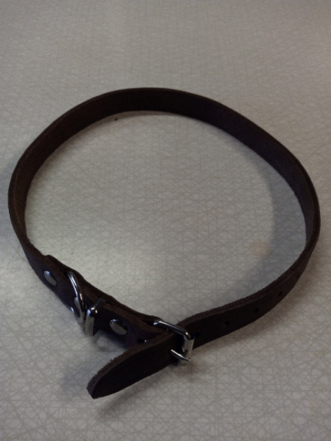 Läderhalsbandets olika storlekar visas på en strukturerad yta med ett silverfärgat spänne.