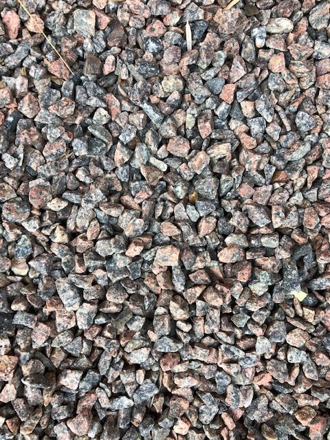 Närbild av Bigbag Makadam 8/11 grå/röd 600kg små, grova, flerfärgade grusstenar.