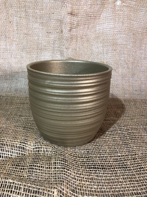 Keramik Kruka Guld, en ribbad brungul planteringskruka, står på säckväv med bakgrund av säckväv.