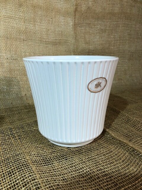 Keramikkruka vit: vit ribbad keramikkruka på brun säckväv med liten oval logotyp på framsidan.