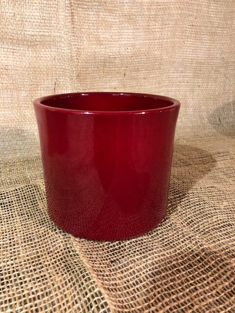 Keramikkruka Röd, en rödglänsande keramikkruka, utställd på juteväv.