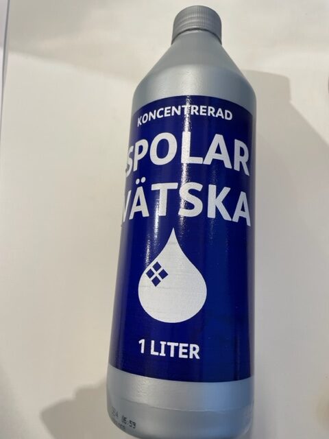 En blå och vit Spolarvätska koncentrerad 1L flaska.
