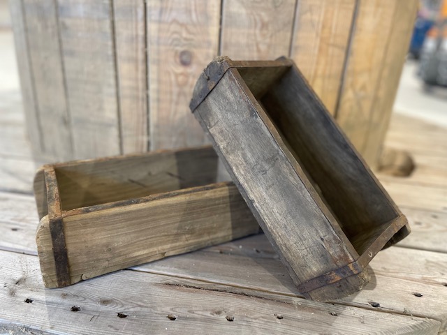 Två Liten Trälåda trälådor på en träyta, med en trätunna bakom dem.