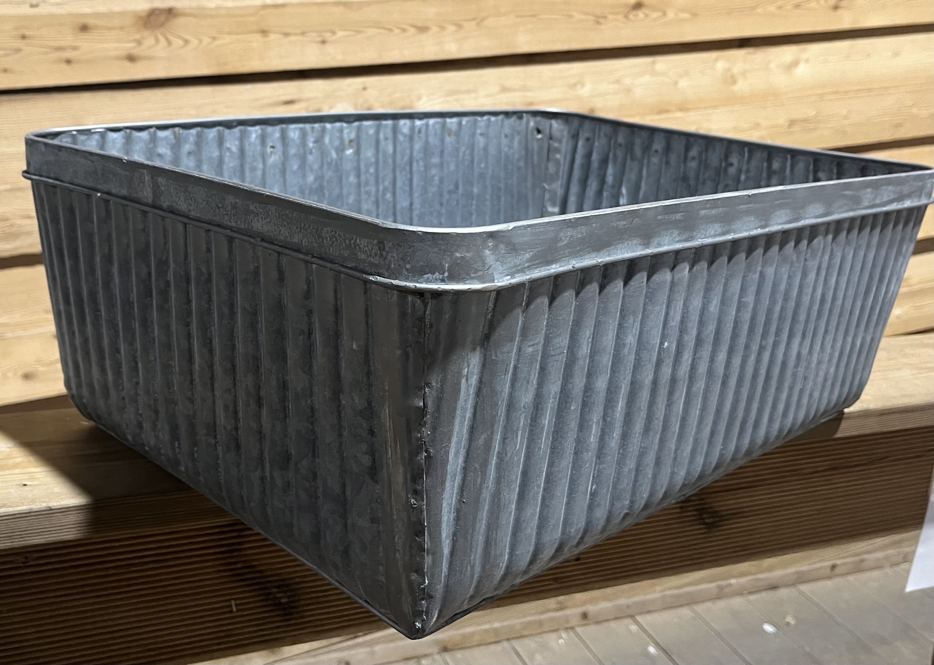 En stor, fyrkantig zinkkruka (ej täta) 39x19x56 mot en bakgrund av träplankor.