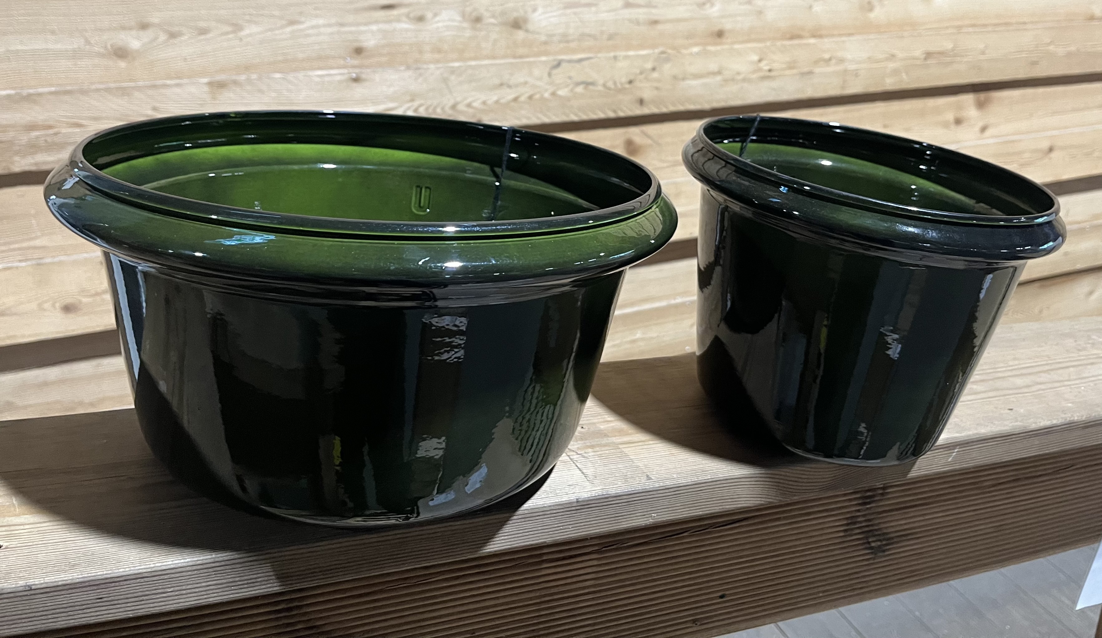 Två blanka Verona-krukor (37x37x27) på en träyta mot en trävägg.