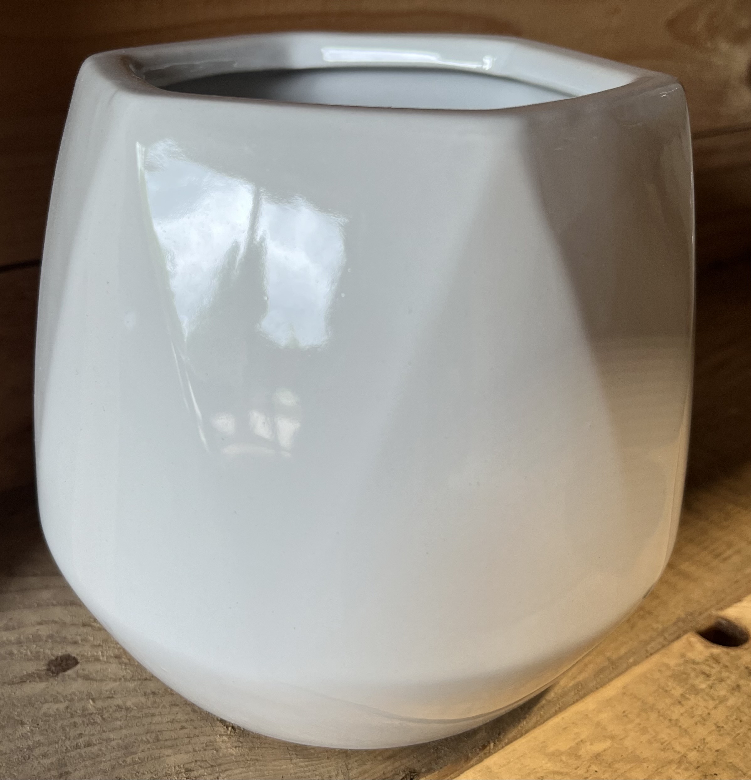 Keramikkruka vit D15 med en geometrisk form på en träyta.