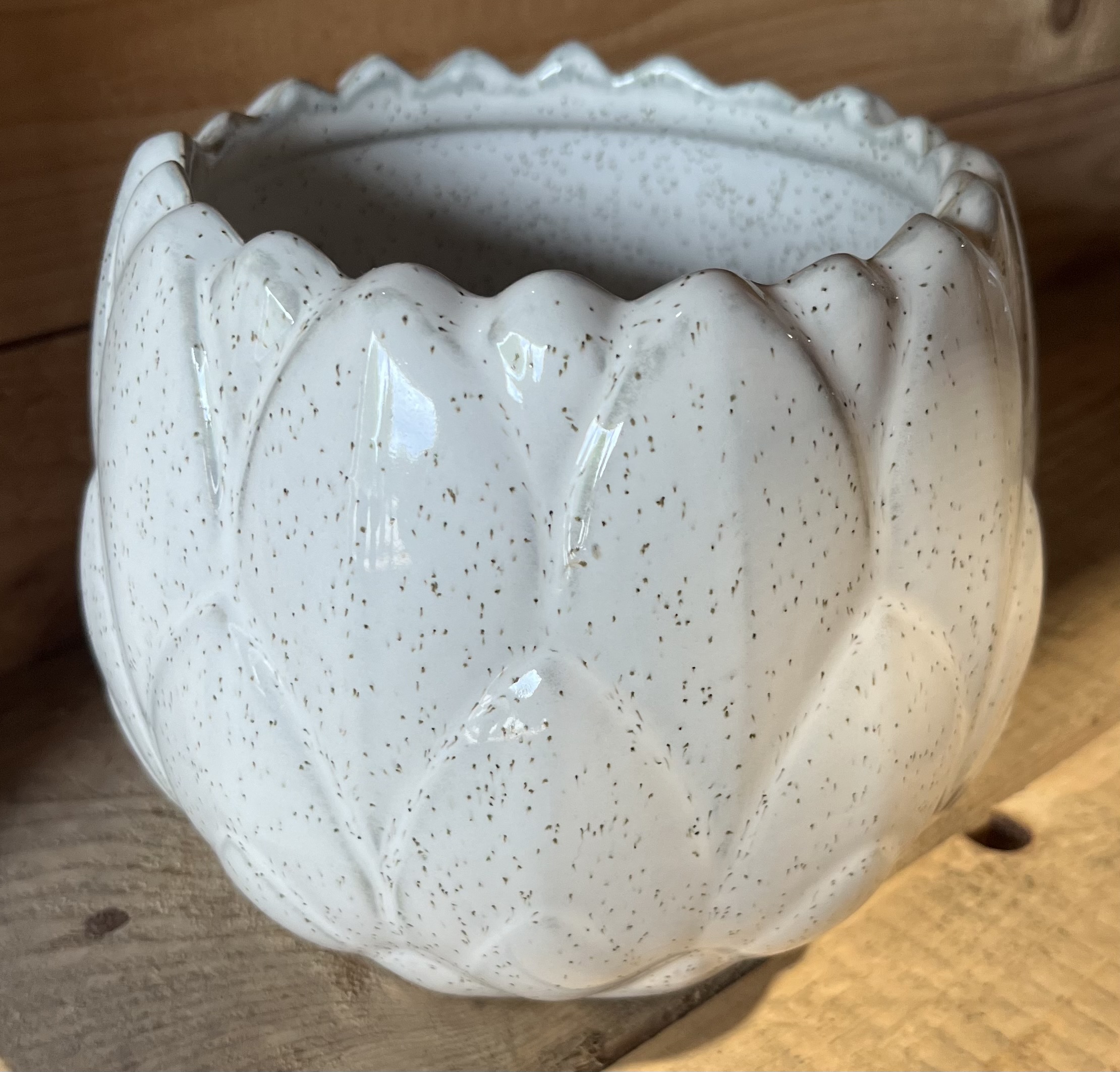 Vit keramikkruka med lövmönster, D15,5, på en träyta.