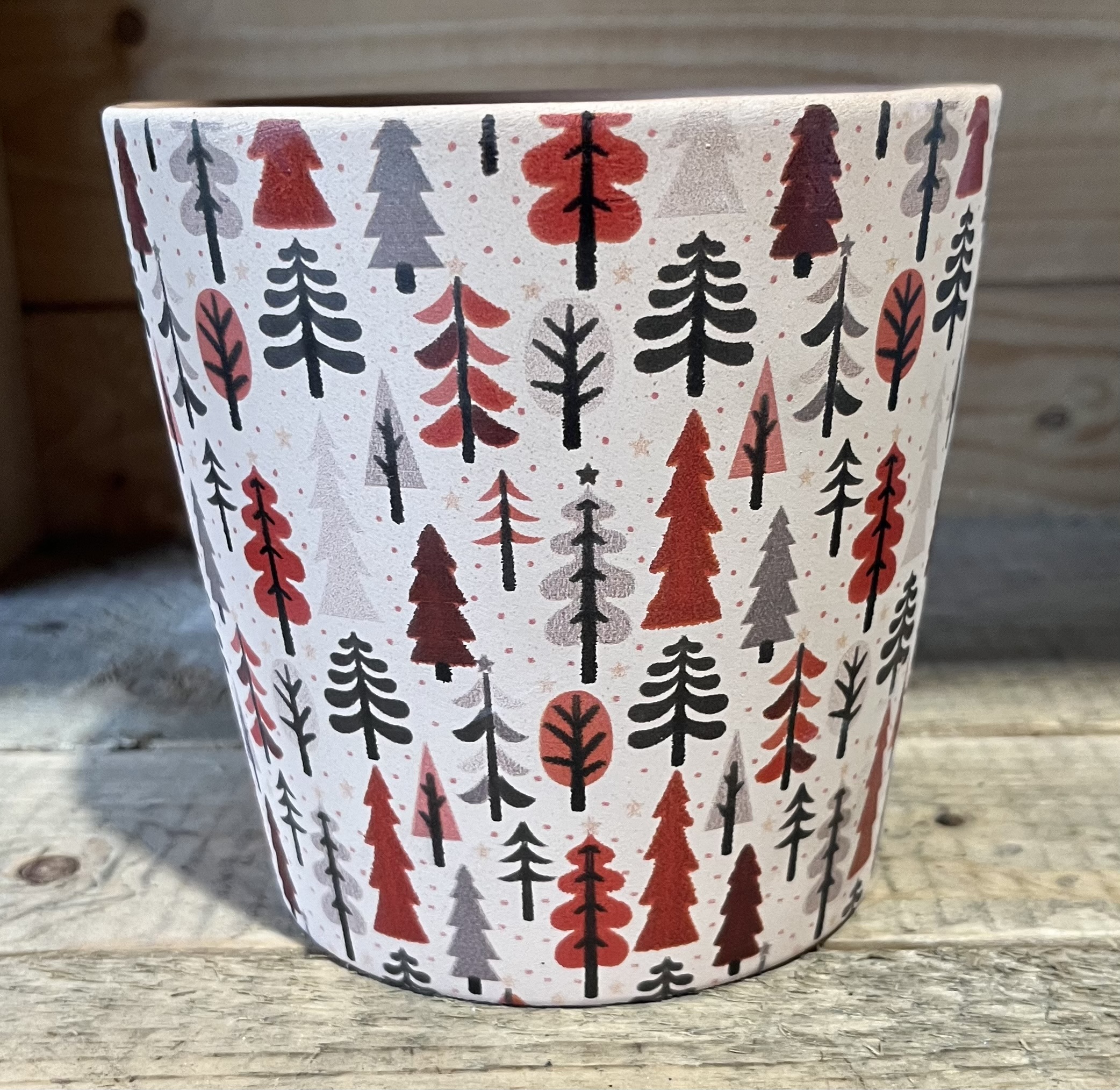 Winterwaldkopp med rött, svart och grått trädmönster på en träyta.