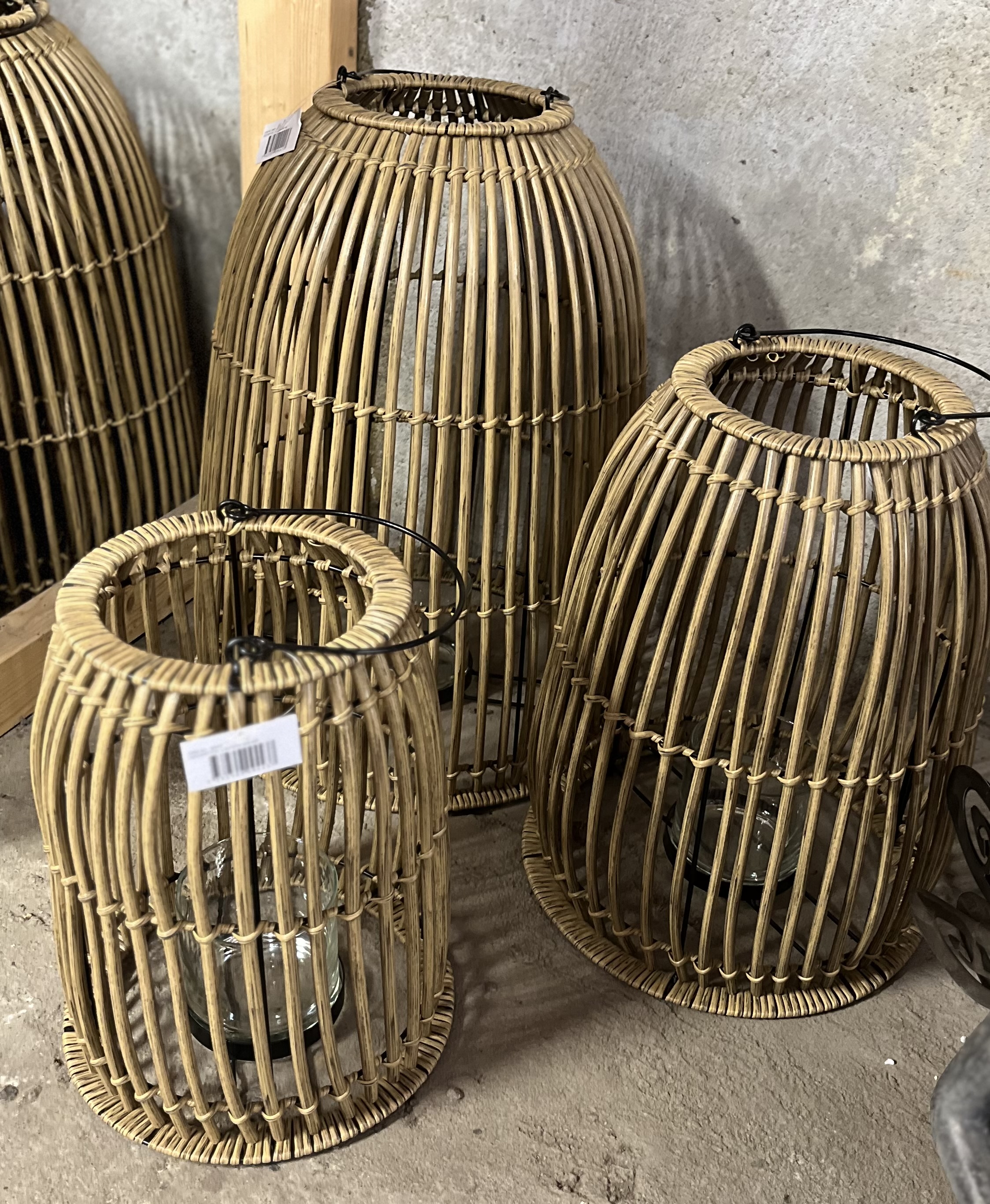 Tre Lykta D26 H33-lanterniner med glasinsatser står på ett betonggolv vid en vägg.