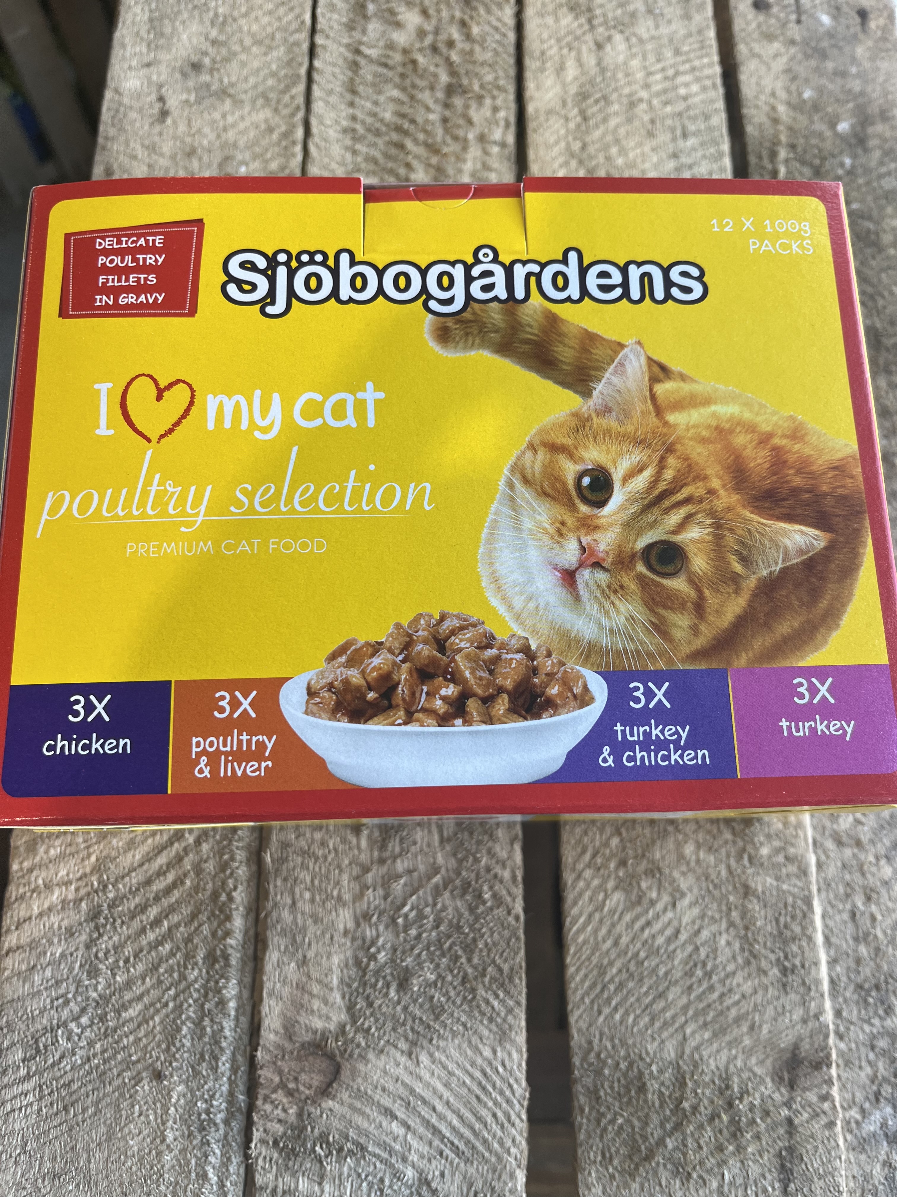 En låda Kattmat 12p Fågelmeny kattmat på en träyta.