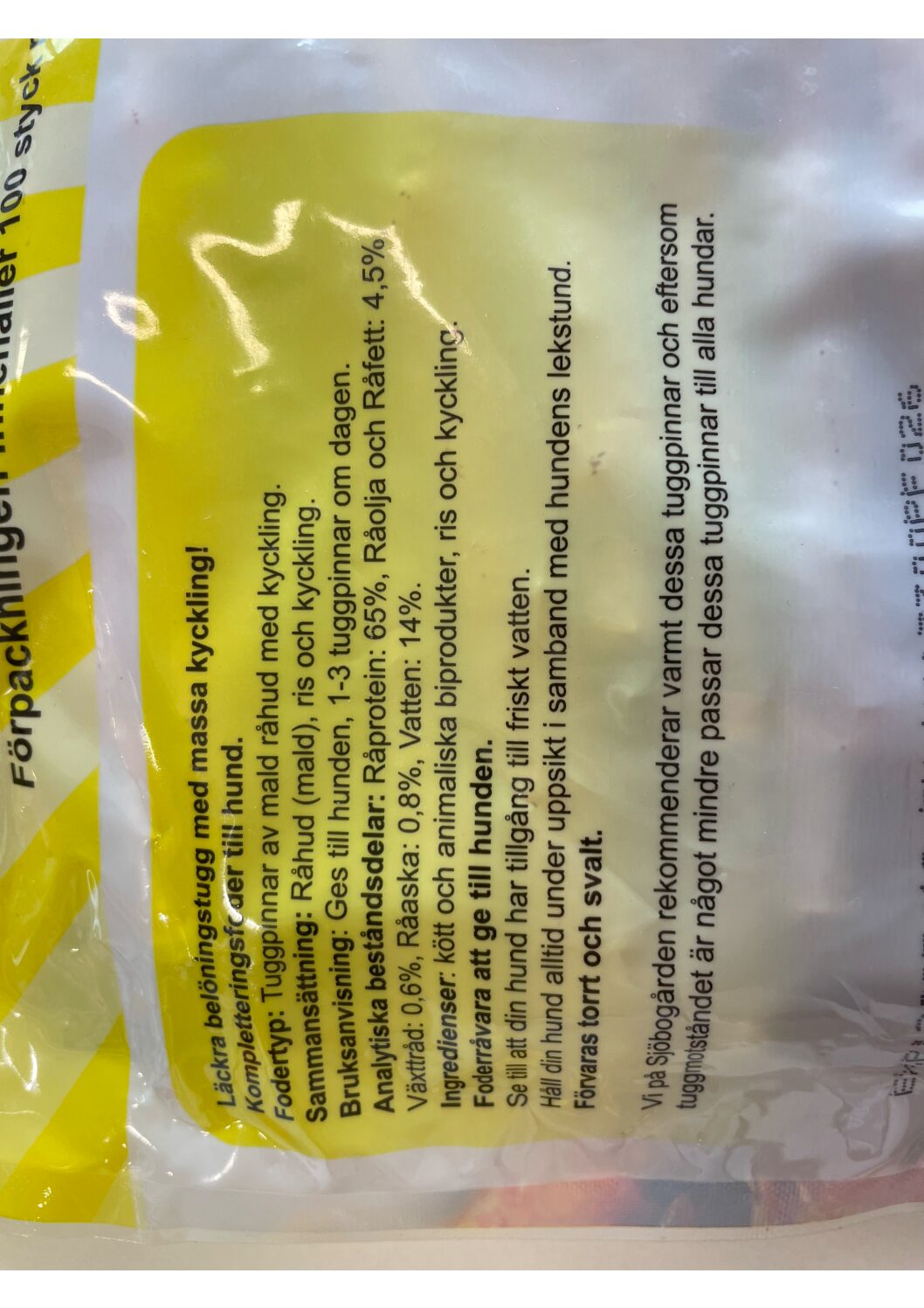 Gul och vit förpackning med svensk text som beskriver hundgodis med kyckling.