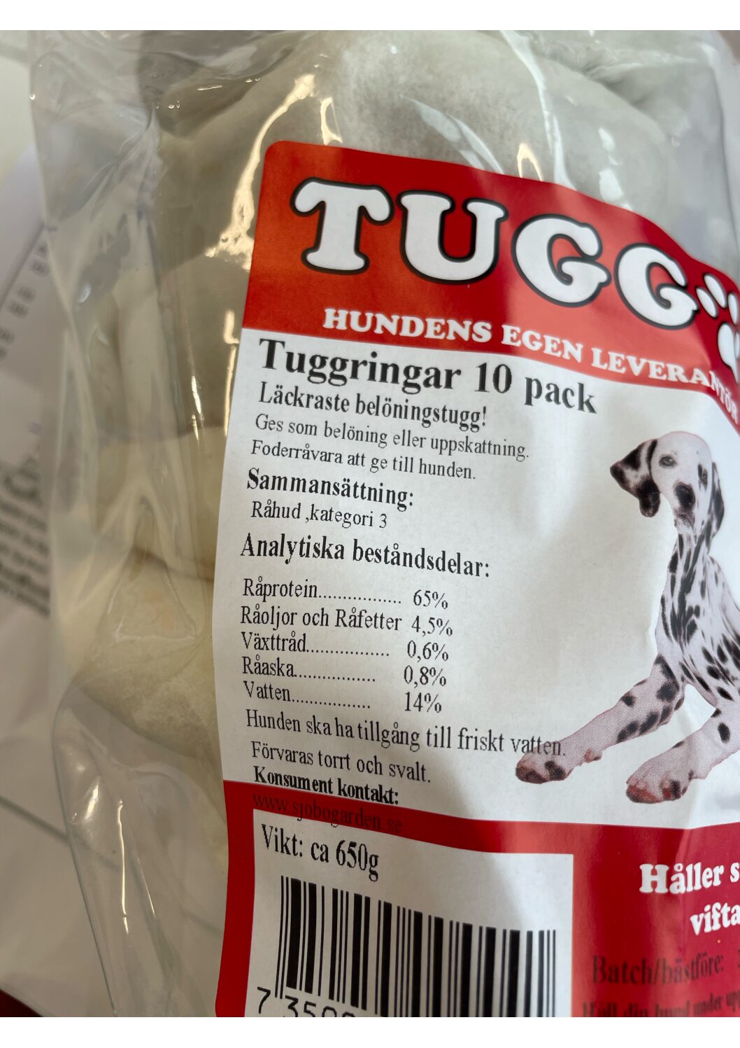 Närbild av ett paket med tuggringar för hundar med text och en dalmatinsk illustration.
