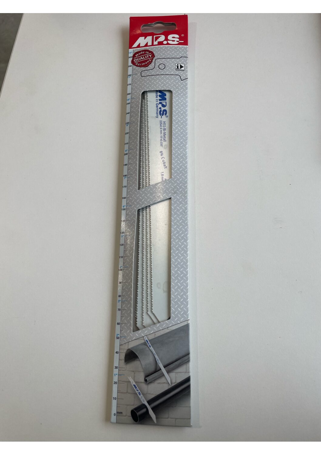 Tigersågsblad 8%CO Metal och trä, trä med spik i förpackning på vit yta, rör syns nedtill.