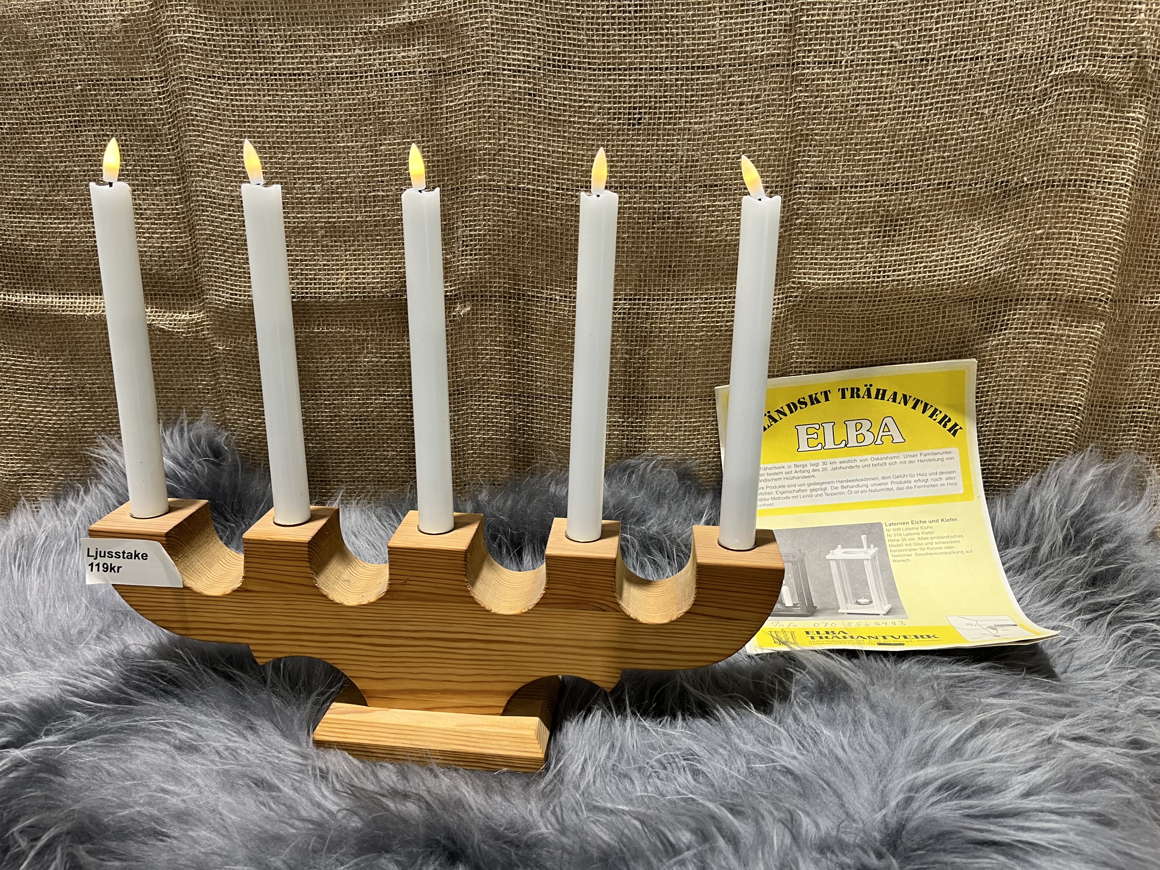 Träljusstake 5 ljus med fem vita ljus på grå päls och ett gult instruktionsblad.