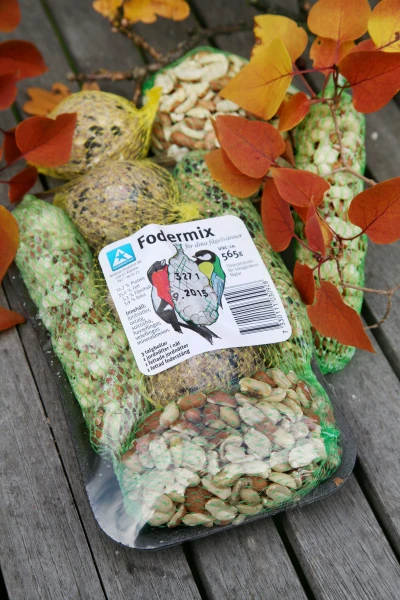 Fodermix 4 sorter 565gr i nätpåsar på en träyta med höstlöv.