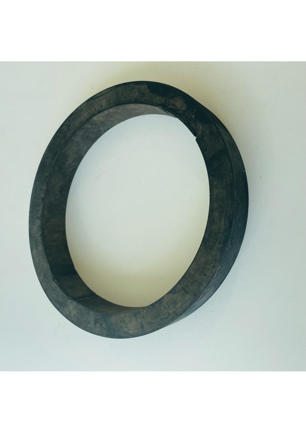 En svart, cirkelformad Tuggring hållbar *Gummiring* på vit bakgrund.