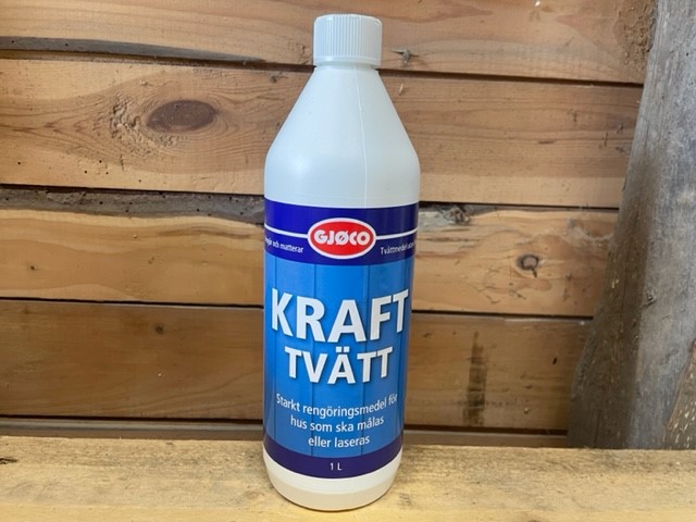 En flaska Krafttvätt 1LITER med en blå etikett på en träbakgrund.