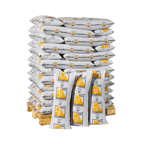 En pall staplad med LAXÅ STRÖPELLETS-påsar, några stående framför.