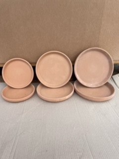 Fyra Lerfat 13 cm Antik runda brickor i terrakotta, uppställda på rad på en ljus yta.