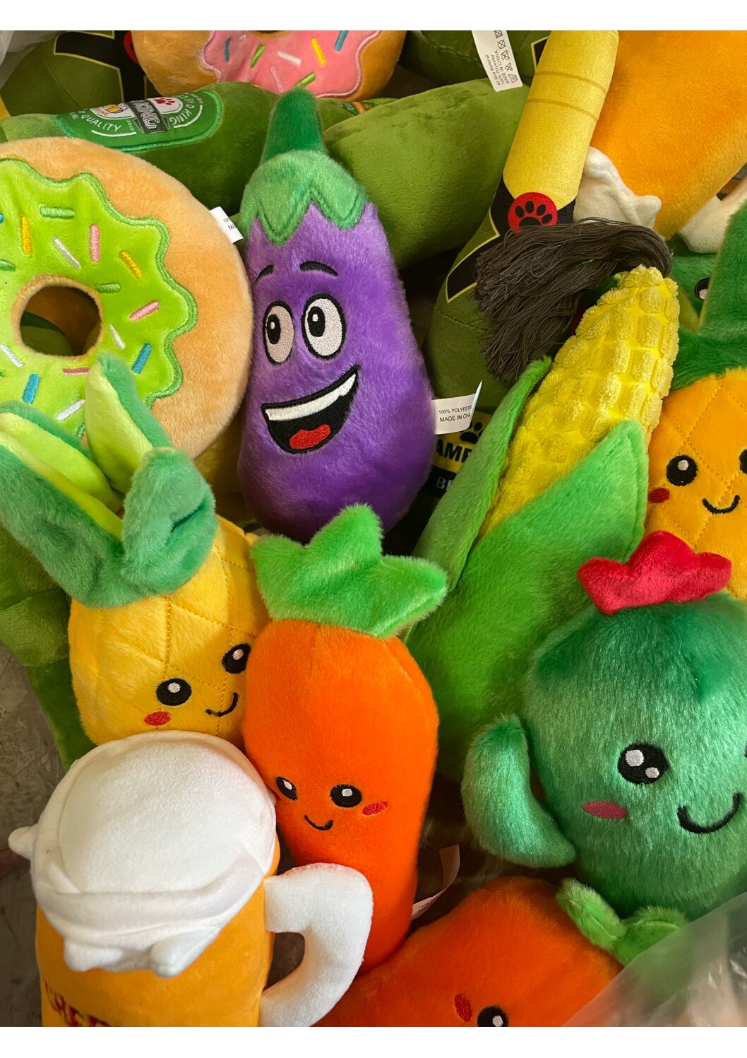 Hundleksak livsmedel olika sorter: plyschleksaker formade som leende frukter, grönsaker & en munk.